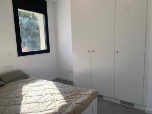 ein Schlafzimmer mit weißen Wänden, einem Bett und einem Fenster in der Unterkunft La Fosca Dream in Palamós