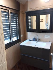 a bathroom with a sink and two windows at Roy Vacation Home in Rishon LeẔiyyon