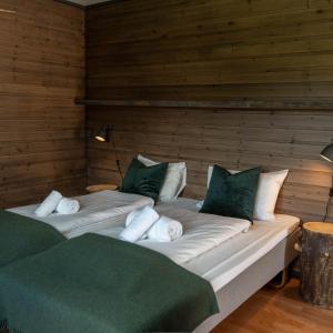 2 łóżka z białymi i zielonymi poduszkami w pokoju w obiekcie Gargia Lodge w Alcie