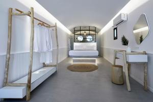 a dressing room with a bed and a mirror at Oscar Beachfront Suites - Adults Only in Perivolos