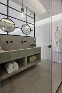 a bathroom with a sink and a mirror at Oscar Beachfront Suites - Adults Only in Perivolos