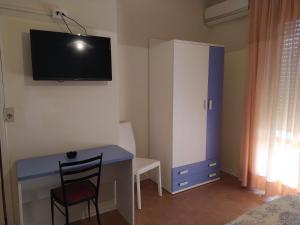 a small room with a desk and a tv on the wall at Hotel Halifax in Lido di Jesolo