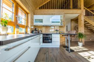 an open kitchen with white cabinets and a table at Chalet Hüttenzauber in Mehlmeisel