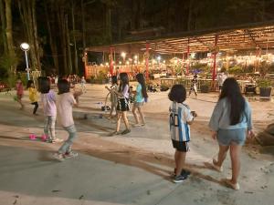 un grupo de niños jugando en un parque por la noche en De Wang Villa, en Meinong