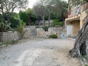 une maison en pierre avec un portail et un mur en pierre dans l'établissement Rez de villa Peymeinade, à Peymeinade