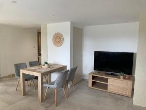 une salle à manger avec une table et une télévision dans l'établissement Rez de villa Peymeinade, à Peymeinade