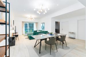 a living room with a table and a green couch at Marina Heights Tower - Vigor Vacations Homes in Dubai