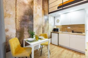 eine Küche mit einem weißen Tisch und gelben Stühlen in der Unterkunft Budapest Holidays Cosy in Budapest
