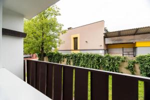 a house with a black fence and ivy at Apartament Lelewela in Częstochowa