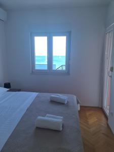 Habitación blanca con 2 toallas en una cama en Apartman Monika, en Marina