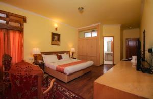 a bedroom with a bed and a television in it at The Druk Ladakh in Leh