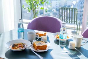 Tokyu Stay Kamata - Tokyo Haneda في طوكيو: طاولة زرقاء مع أطباق من الطعام وزجاجات الماء