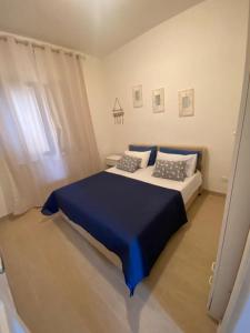 a bedroom with a large bed with a blue blanket at Hibiscus Apartment-casa per le vacanze vicino tropea in Briatico