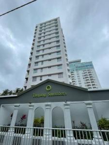 タンピンにあるNR Homestay Pantai Puteri Melakaの白い高い建物の上に看板