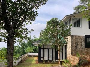 uma casa com janelas pretas e uma árvore em Miracle Trail Kandy em Kandy