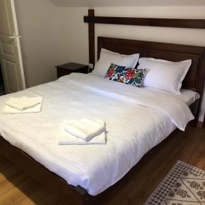 a large white bed with two white towels on it at Casa pintioi in Ieud