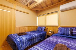 宇流麻宇堅ビーチまで車で3分 琉球古民家を堪能できる貸切別荘 洋奈月的一间木墙房间里有两张床