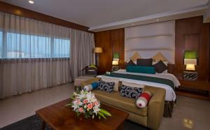 a bedroom with a large bed and a couch at The Raviz Calicut in Kozhikode