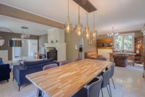 a large living room with a wooden table and chairs at La Villa Cyrano - Maison avec piscine privée in Bergerac