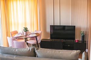 a living room with a television and a table with chairs at ROSE Luxury Apartments in Lublin