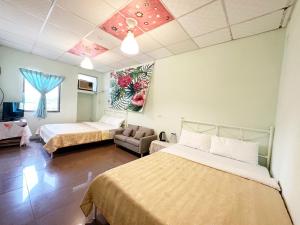 De Wang Villa في Meinong: غرفة فندقية بسريرين واريكة