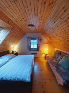 a bedroom with a large bed and a wooden ceiling at Chata DOBROTKA in Liptovský Mikuláš
