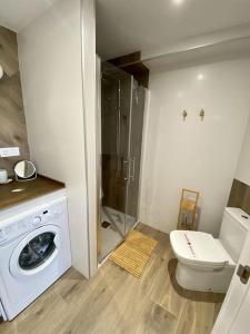 a bathroom with a washing machine and a toilet at For a Stay Horizonte Mar in Cambrils +21 photos