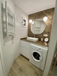 een badkamer met een wasmachine en een spiegel bij For a Stay Horizonte Mar in Cambrils