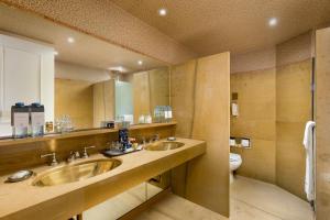 a bathroom with two sinks and a toilet at Sheraton Buenos Aires Hotel & Convention Center in Buenos Aires