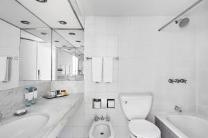 a white bathroom with a toilet and a sink at Sheraton Buenos Aires Hotel & Convention Center in Buenos Aires