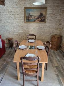 - une salle à manger avec une table et des chaises en bois dans l'établissement Le verger des noyer Relaxing getaway with private pool, à Mairé-lʼEvescault