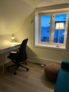 a desk and a chair in a room with a window at Koselig hus nært havet i Lofoten, Kabelvåg in Kabelvåg