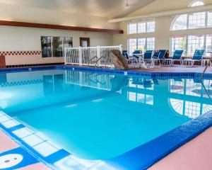 una gran piscina con sillas y mesas en Comfort Inn & Suites and Conference Center en Mount Pleasant