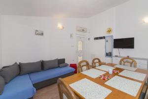 een woonkamer met een blauwe bank en een tafel bij Apartments Besa in Pirovac
