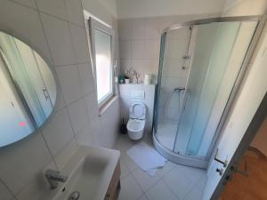 La salle de bains est pourvue d'un lavabo, de toilettes et d'un miroir. dans l'établissement Apartman Monika, à Marina