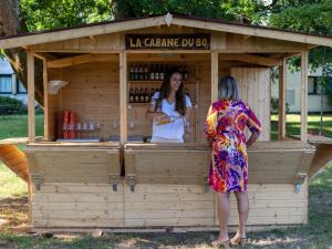dos mujeres de pie en frente de un puesto de bebidas en Novotel Bordeaux Mérignac en Mérignac