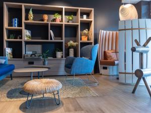 uma sala de estar com cadeiras azuis e uma mesa em Novotel Bordeaux Mérignac em Mérignac