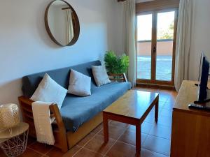 - un salon avec un canapé bleu et une table dans l'établissement Apartamento Superesquí 251, à La Molina