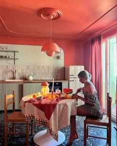 Una donna seduta a un tavolo in una cucina di Apartamento No5 a Gandía