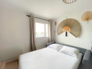 1 dormitorio con cama blanca y ventana en Le Côte d'Opale en Calais
