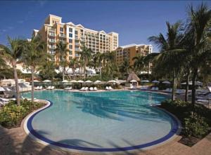 une grande piscine avec des palmiers et des bâtiments dans l'établissement Unique 1BR Suite Condo Located at Ritz Carlton-Key Biscayne, à Miami