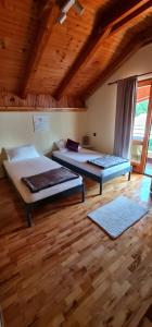 a bedroom with two beds and a wooden ceiling at Apartment TRIO FANTASTICO in Podaca