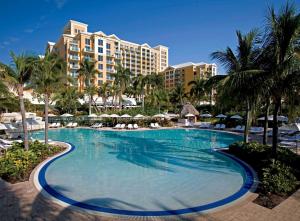 a large swimming pool with palm trees and buildings at Lovely Deluxe Unit Located at Ritz Carlton - Key Biscayne! in Miami