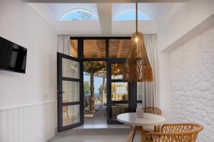 a dining room with a table and a chandelier at Oscar Beachfront Suites - Adults Only in Perivolos