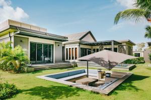 a house with a pool and an umbrella at 04-Biệt thự cao cấp Hồ Tràm-3BR SUPER KINGS, Hồ bơi to,BBQ, cầu ra ngắm biển in Xuyên Mộc