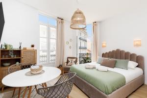 Un dormitorio con una cama y una mesa y sillas. en Comfortable studio W balcony Cannes center TGV, en Cannes