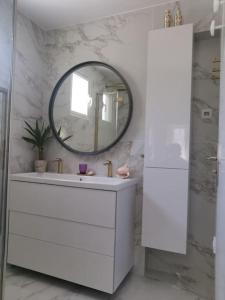 a white bathroom with a sink and a mirror at La petite Niçoise au Jacuzzi à 3 min de la mer in Nice +15 photos