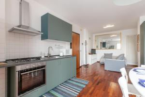 uma cozinha com armários azuis e uma sala de estar em Casa Pozzetto - Cittadella em Cittadella