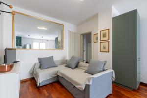 uma sala de estar com um sofá e um espelho em Casa Pozzetto - Cittadella em Cittadella