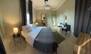 a bedroom with a large bed and a desk in it at Beit Mirna Guesthouse & Chalet - Ehden in Ehden